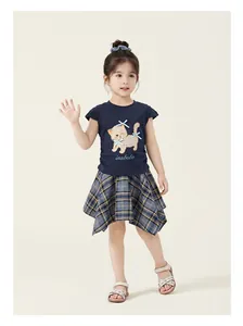 Dettaglio di un completo estivo per bambina con t-shirt gatto e gonna a quadri