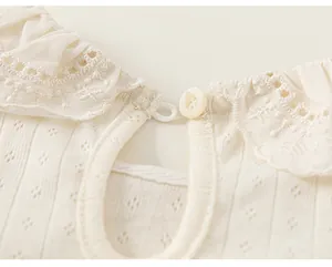 Close-up of elegant lace collar and button detail on girl's cotton ribbed top.