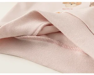 Dettaglio dell'orlo a costine e cuciture sottili su una felpa rosa da bambina di alta qualità