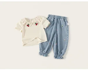 Close-up of toddler girls' summer set with lace collar cherry tee and floral denim pants
