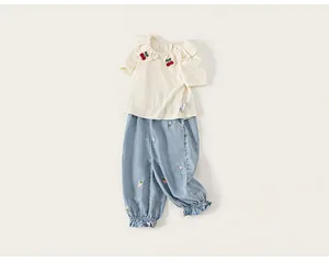 Detail view of toddler girl summer clothing set with cherry embroidery and lace collar
