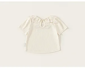 Close-up of cream girl's short sleeve T-shirt featuring intricate lace collar detail