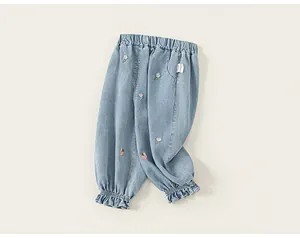 Detailed view of toddlers light blue denim pants with floral and strawberry embroidery