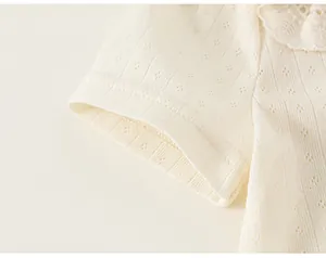 Macro view of cream girl's t-shirt showing refined lace collar and pointelle knit