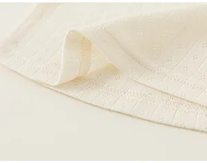Close-up detail of cream pointelle ribbed fabric and neat stitching on girls' T-shirt