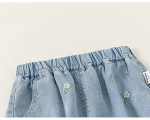 Close-up of girls' light blue denim shorts with elastic waist and floral embroidery