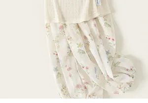 Close-up detail of a girls' summer dress with cream knitted top and floral print fabric