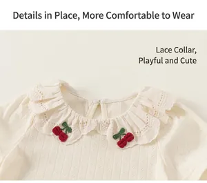 Close-up of girl's white T-shirt featuring a lace lapel and red cherry embroidery detail