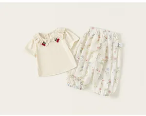 Detail of girls summer set featuring cherry embroidered top and floral print pants