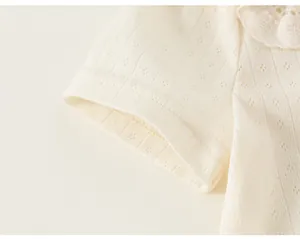Close-up detail of cream pointelle knit fabric and embroidered lace collar for girls