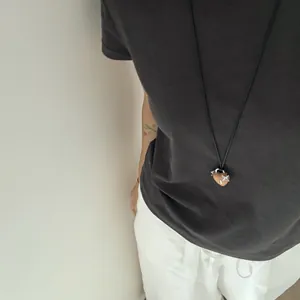 Collana con ciondolo a cuore bifacciale in legno e resina stile francese indossata.