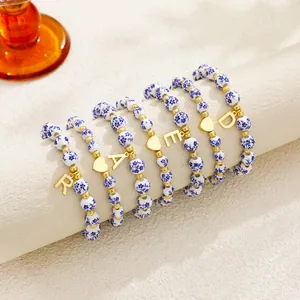 Detail view of blue and white porcelain bead bracelets with gold initial charms