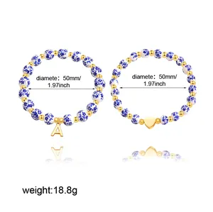 Detailed view of blue and white porcelain beaded bracelets with gold heart and letter A charms