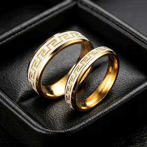 Close-up of gold-plated titanium steel rings with a classic Greek meander pattern