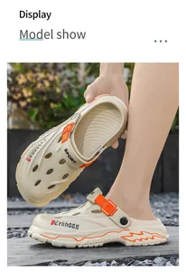 Detail view of men's breathable clogs with orange accents in outdoor setting.