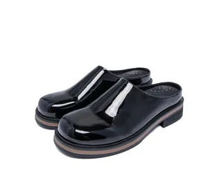Sabot da uomo in vernice nera lucida con suola platform spessa e punta tonda chiusa.