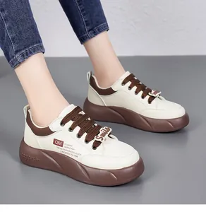 Détail de baskets de mode crème avec semelle compensée marron et breloque Smile