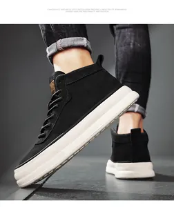 Close-up detail of black suede mid-top sneakers featuring a chunky white platform sole
