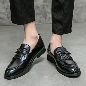 Mocasines de cuero negro para hombre con borlas y lazo, estilo formal retro elegante.