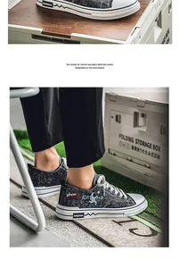 Dettaglio di scarpa in tela denim traspirante con grafica astronauta e stringhe.