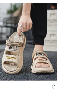 Nahaufnahme beiger EVA-Plattform-Sandalen mit dem aufgedruckten Schriftzug 'SMILE'