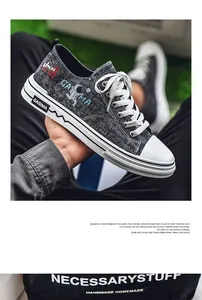 Vista macro dettagliata di sneakers in tela denim nera alla moda con grafica astronauta.