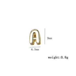 Gedetailleerde macro-opname van een mini gouden letter A bedeltje met 9 mm afmeting