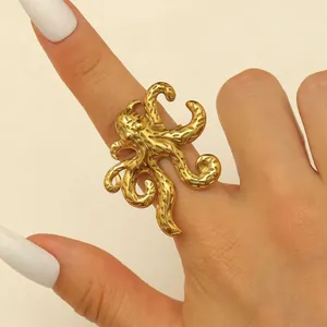 Macro view of a polished golden stainless steel ring with a detailed octopus design
