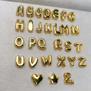 Close-up van een volledige set van 26 glanzende gouden letterbedeltjes met hart en ster.