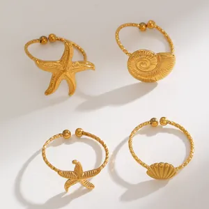 Detailed view of four gold-plated stainless steel ocean-themed adjustable rings.