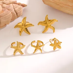 Detail view of various textured stainless steel starfish open rings in gold finish