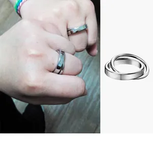 Detail of interlocking stainless steel rings with a simple polished finish for couples
