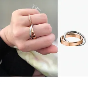 Close-up of minimalist interlocking double ring in rose gold and silver finish