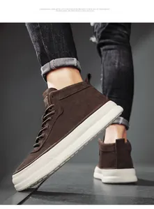 Close-up of brown suede high-top sneakers with thick white platform soles on a model