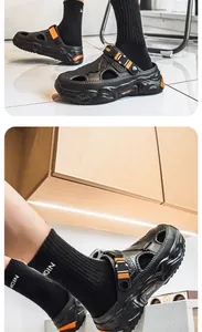 Detail view of men's black thick-soled beach clogs with orange accent buckles