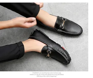 Close-up of men's black leather slip-on loafers with metal buckle and stitch detail