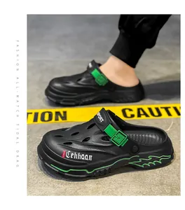 Detail view of breathable black and green men's designer clogs on street background