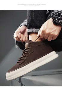 Detail view of brown suede mid-top outdoor sneakers with thick white rubber soles.