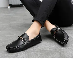 Close-up of men's black leather slip-on loafers with white stitching and gold buckle
