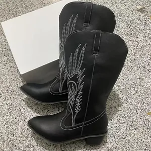 Detailed side view of black PU leather women's cowboy boots featuring white embroidery and mid heel