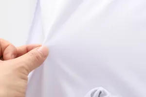 Nahaufnahme der weichen weißen Stoffstruktur und Elastizität des Jungen-Badeanzugs.