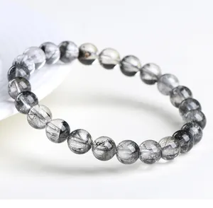 Vista detallada de cuentas de cristal de cuarzo rutilado negro natural en una pulsera
