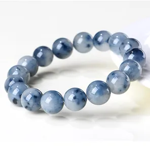 Macro view of a natural blue rabbit hair rutilated quartz beaded bracelet on white background