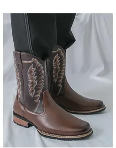 Nahaufnahme von braunen Vintage-Westernstiefeln mit Stickerei und Reißverschluss.