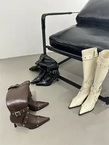 Detail view of retro high boots in black, brown and cream with studded straps