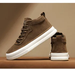 Professional close-up of brown suede mid-top workwear sneakers featuring a thick white sole.