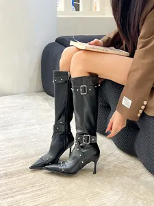 Pointed toe high heel knee-high black boots featuring stud and buckle metal details