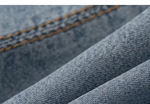 Vista macro detallada de la textura del tejido vaquero azul con detalles de costura