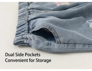Detalle de bolsillos laterales y cintura elástica en pantalones vaqueros azules para niña