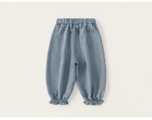 Vista trasera de pantalones bombachos vaqueros azul claro para niña con bonitos volantes